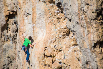 A rock climber ascends to the summit via a difficult route.