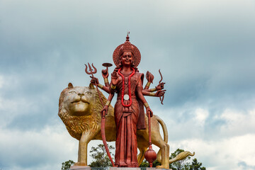 A powerful Statue of the Hindu goddess Durga Maa with a golden lion in sacred Ganga Talao. Shiva...