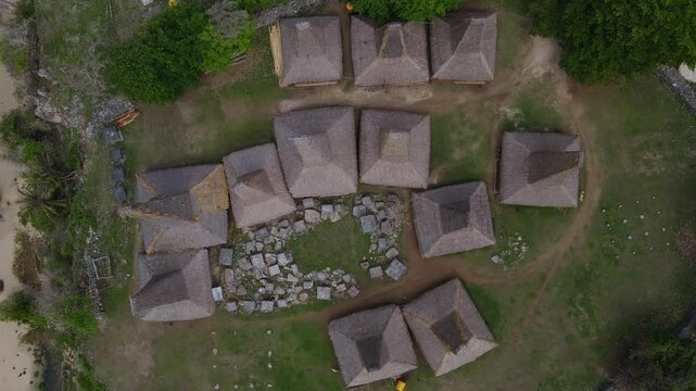 Traditional buildings at ocean coastline at sunny day. Sumba island. Indonesia