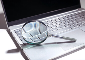 SEO search concept with magnifying glass on a website. Web research and engine optimization in a