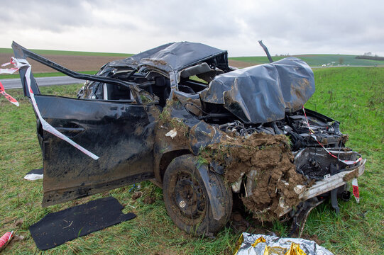 Voiture noire accident&eacute;e et compl&egrave;tement d&eacute;truite dans un champ, apr&egrave;s avoir effectu&eacute; plusieursd tonneaux. 