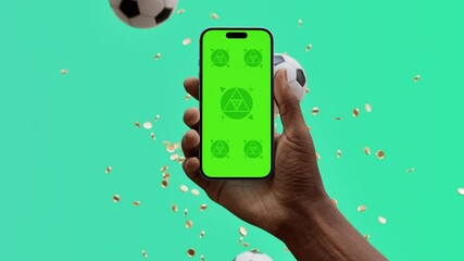 A hand holds smartphone with green mockup screen, surrounded by floating soccer balls and coins. The vibrant scene evokes a sense of interactive gaming, sports betting, or rewards-based app engagement