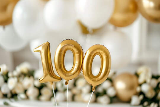 
Helium golden balloons in shape of number 100. Birthday jubilee party or wedding anniversary for one hundred years celebration. Elegant white decorations. 100 followers or likes in social media