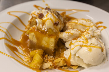 Cheese cake, bananas, caramel dessert. Making dessert behind the scenes. Vanilla Ice cream, whip cream topped on cheese cake, banana sauce topping with caramel on top. 