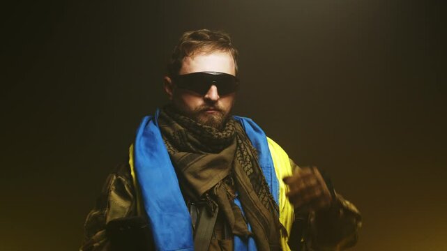 A military man, wrapped in a Ukrainian flag, takes off his military clothes. Concept of victory, war and perseverance.