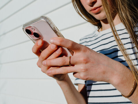 Young teenage girl holding a mobile device.
