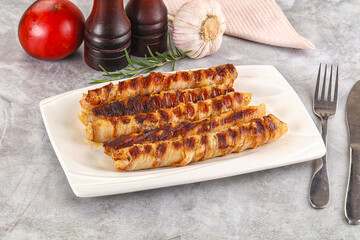 Grilled meat sausages wrapped bacon