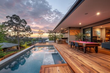 Fototapeta premium Luxury Backyard with Wooden Deck, Pool, and Snooker Table at Sunset. Modern Home and Suburban View in Golden Hour Lighting.