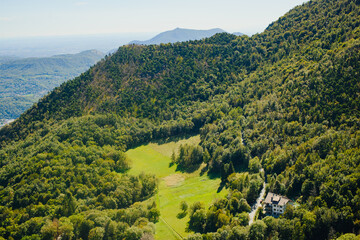 Obraz premium Panoramic landscape of the Italian city, photos from a drone, quadcopter, aerial photography. The city, the houses with tiled roofs, the road and the mountains. Layout. A miniature. View of Piedmont, 