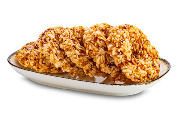 Crispy homemade rice crackers in brown ceramic tray with dark edge isolated on white background with clipping path.