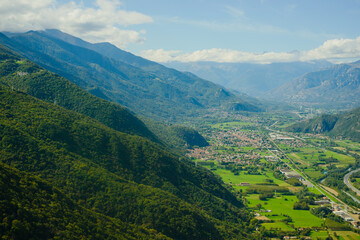 Fototapeta premium Panoramic landscape of the Italian city, photos from a drone, quadcopter, aerial photography. The city, the houses with tiled roofs, the road and the mountains. Layout. A miniature. View of Piedmont, 