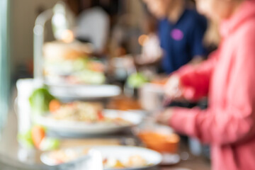 Blurred people take international buffet food in hotel party.