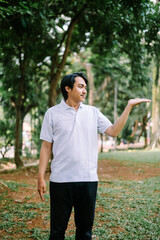 Southeast Asian man showing something with his right hand, highlighting an object or idea.