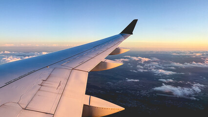 Obraz premium L’aile d’un avion en vol au-dessus des nuages.