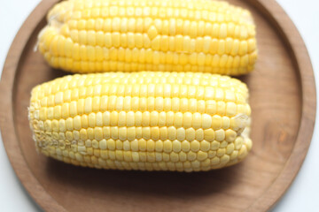 Fresh Corn Cobs on Wooden Plate. Selective Focus. 