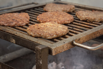 Burger meat steaks are cooked on hot coals.