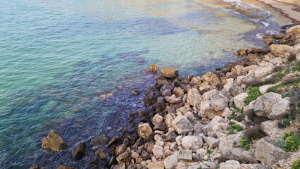 Balearic Sea, Salou, Spain. Beach, turquoise transparent sea, small waves. Landscape on the coast, rocks. Vacation at sea