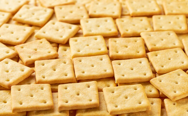 Square crackers placed throughout the screen selective focus. Food background.