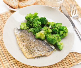 Dish of fried dorado fish fillet with boiled broccoli