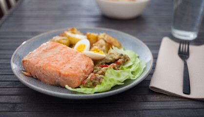 Steamed salmon fillet with potato wedges, guacamole homemade and quail egg