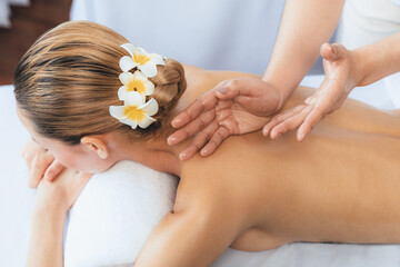 Caucasian woman customer enjoying relaxing anti-stress spa massage and pampering with beauty skin recreation leisure in day light ambient salon spa at luxury resort or hotel. Quiescent