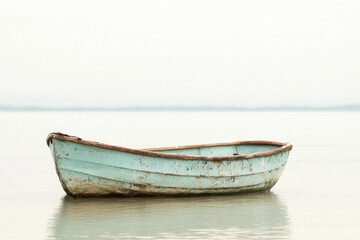A rusty old boat sitting quietly near the shore, evoking nostalgia and history.