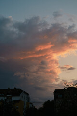Serene Twilight Sky Over small town Novi Sad in Serbia country with Deep Blue, orange and Pink Clouds. A house in a suburban neighborhood with a stunning, vibrant sunset sky backdrop.