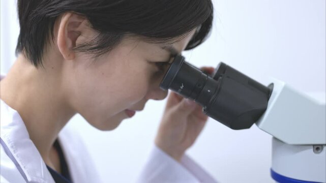 顕微鏡を使う研究職の女性