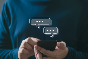 Person using smartphone with chat icons appearing above. Concept of digital communication, text...