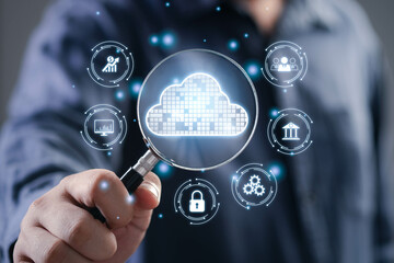 A person examines cloud computing symbols through a magnifying glass, showcasing digital connectivity and data security concepts.