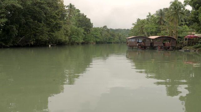 Wooden cottages on a river in a tropical forest in the Philippines