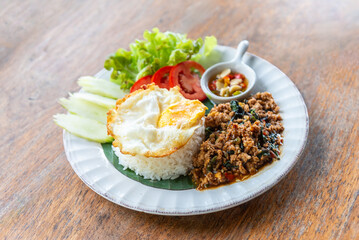 Spicy fried pork with basil leaves, the famous traditional Thai food served with jasmine rice and fried egg.
