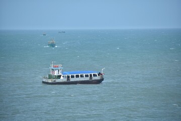 A closeup picture of a steamer or a ferry floating in the middle of the ocean on a sunny day.