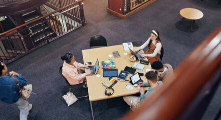 Above, laptop and studying of group, library and browsing of web, education and friends with...