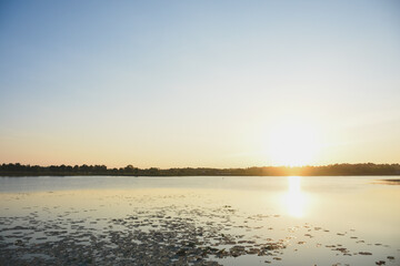 Fototapeta premium Sunset water surface and shadows of trees