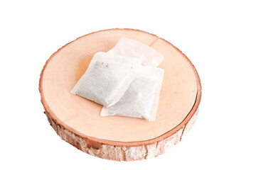 Three tea bags are sitting on a wooden surface