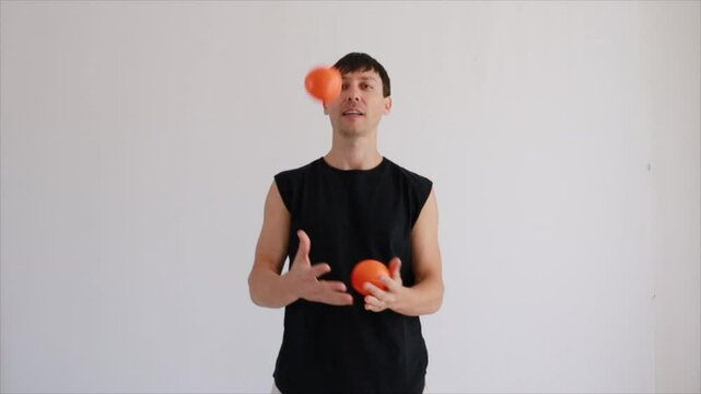 homem faz malabarismo com laranjas 