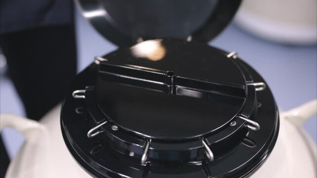 液体窒素タンクでサンプルを管理する実験者の手元