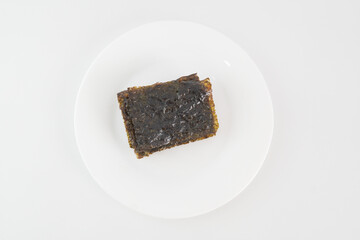 A plate of seaweed snacks sits on a white table