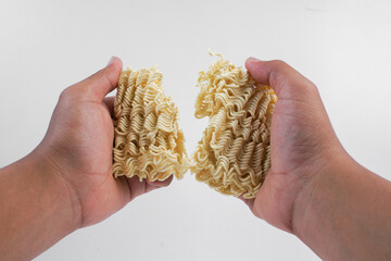 Hand holding raw instant noodle isolated on white background.