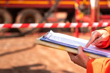 Action of a supervisor is checking on paperwork document during perform safety audit at operation...