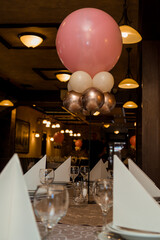 Pink, white and gold balloons as decoration on the table that is ready for lunch