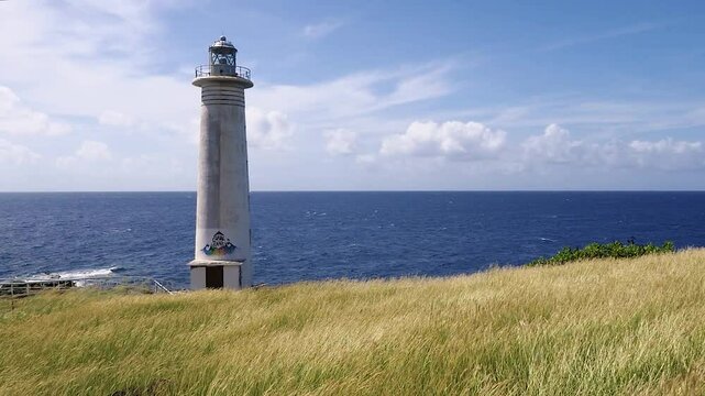 Camera passing through a field of grain with a view of the lighthouse on the seashore in Guadeloupe Slow Motion