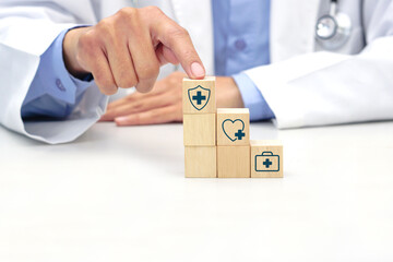 Hand holding a wooden block cube with healthcare medical symbol. Medical and health concept.