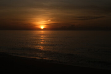 The sun rises at the sea in the morning.
