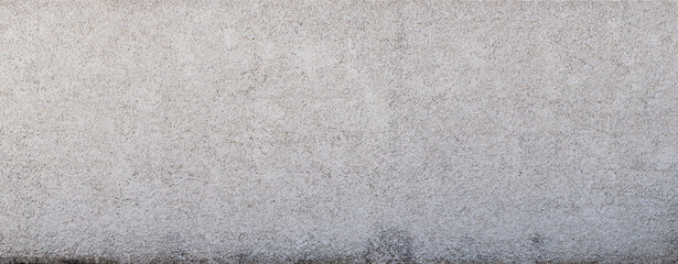 Background of textured wall with granulated cement in a light gray color at the top, transitioning...