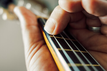 close up of human hand playing Ukulele