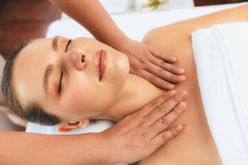Caucasian woman customer enjoying relaxing anti-stress spa massage and pampering with beauty skin recreation leisure in day light ambient salon spa at luxury resort or hotel. Quiescent