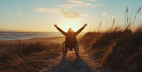 Woman in a wheelchair celebrating the sunset on a beach, arms raised in joy.