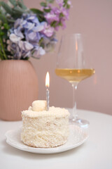 An Elegant Celebration Cake beautifully adorned with a Candle and a fine glass of Wine